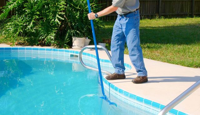 Ein Mann reinigt einen Pool